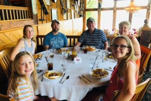 OWNERS AND FAMILY DINING AT GASTONS RESTAURANT WIHICH HANGS OVER THE WHITE RIVER